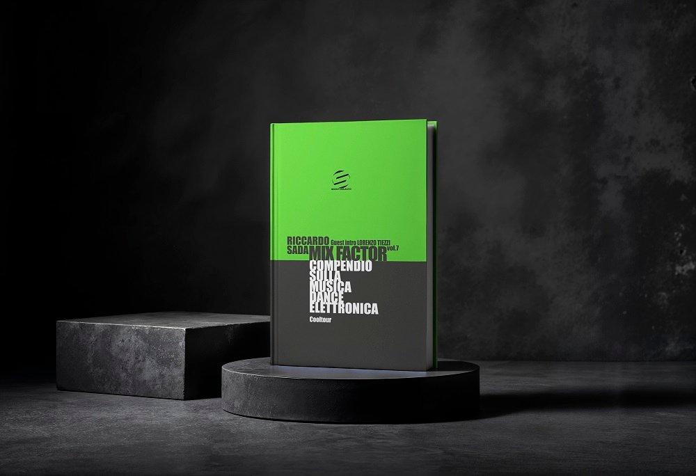 Green-and-black hardcover book displayed on a round pedestal in a dark, moody studio setting.